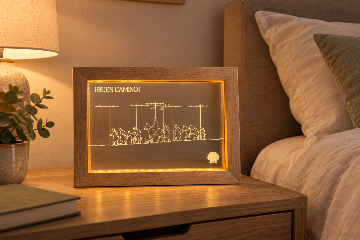 Pilgrim Artifact Alto del Perdón Camino LED frame displayed beside a bed in an evening setting.
