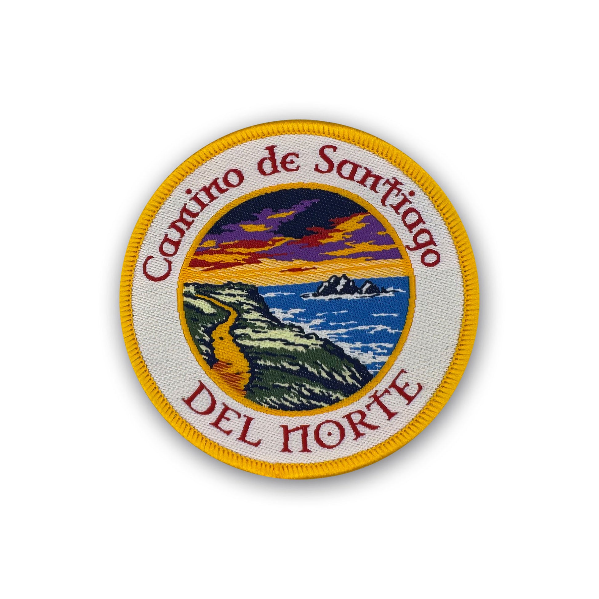 Camino del Norte patch showing a path on a cliff overlooking the water under a fiery sky on white background
