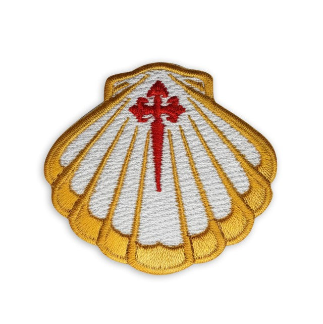 Close-up of fully embroidered scallop shell patch with red Cross of Saint James and gold satin-stitch border on white background
