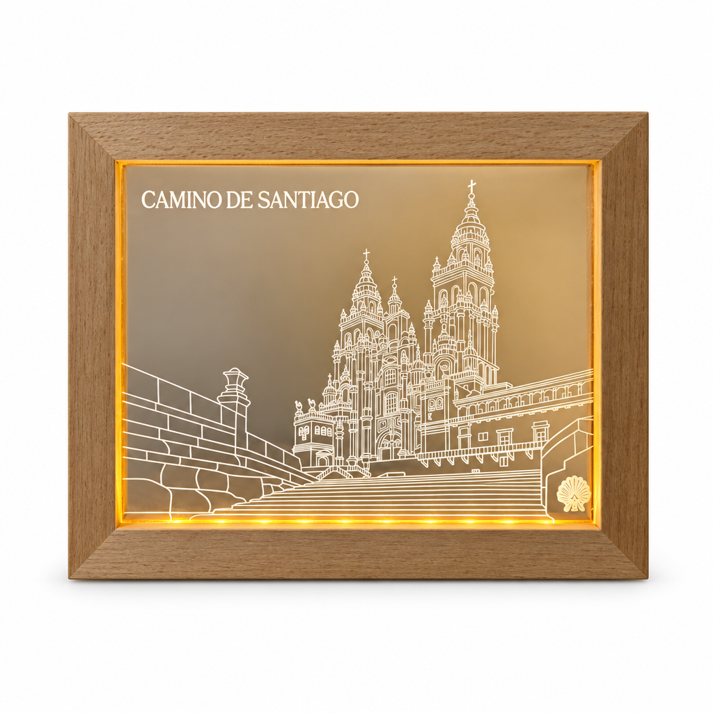 Camino de Santiago LED frame with white engraved cathedral line art and a warm glowing LED strip, shown lit on a pure white background.