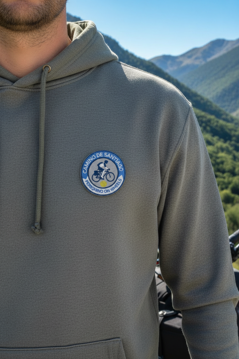 Peregrino On Wheels Camino de Santiago patch on the chest of a grey hoodie