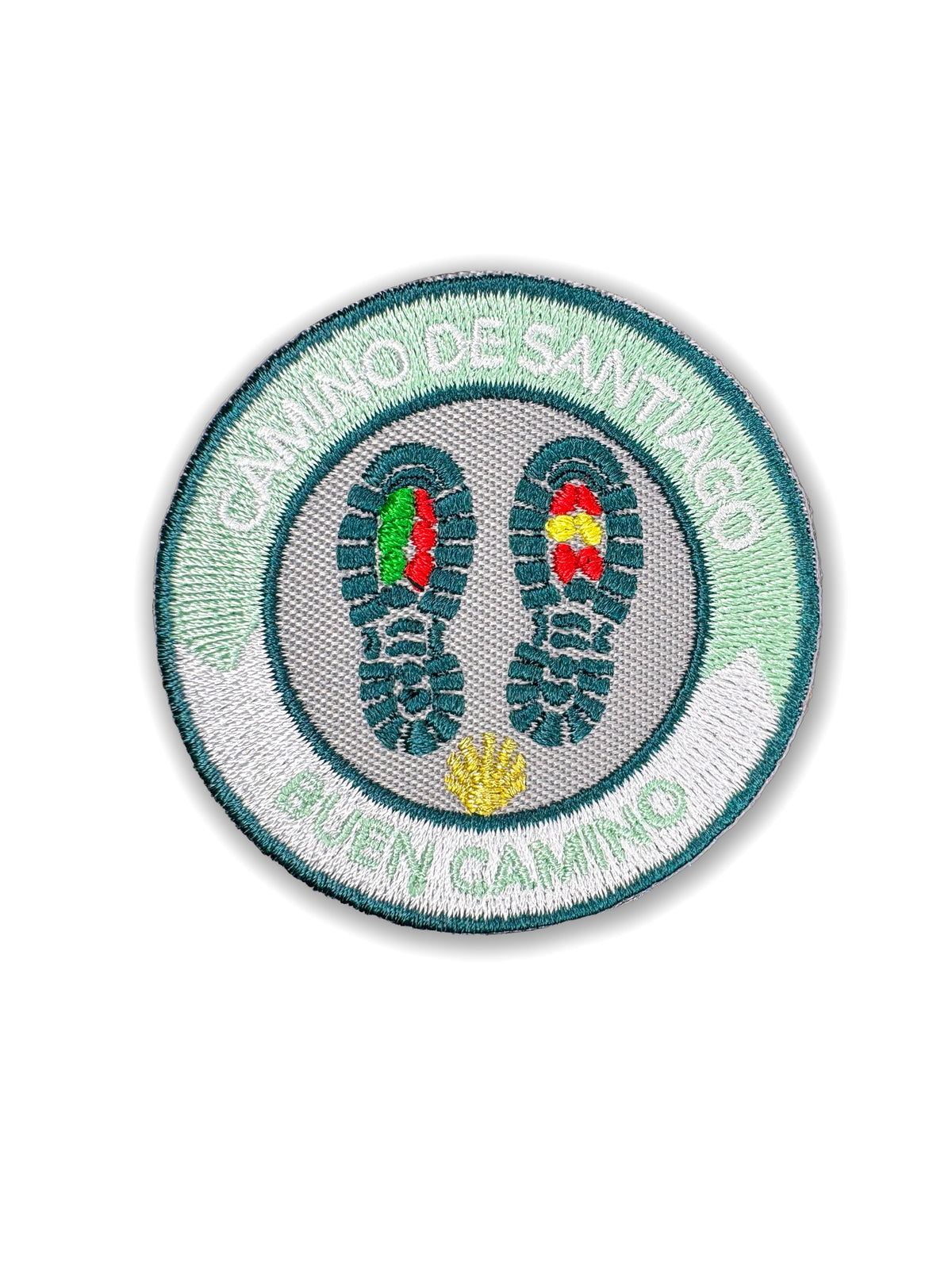Pilgrim Artifact Buen Camino On Foot embroidered iron-on patch with teal boot prints containing Portuguese and Spanish flag colors, a gold scallop shell, and a mint green and white border, shown on a white background. 