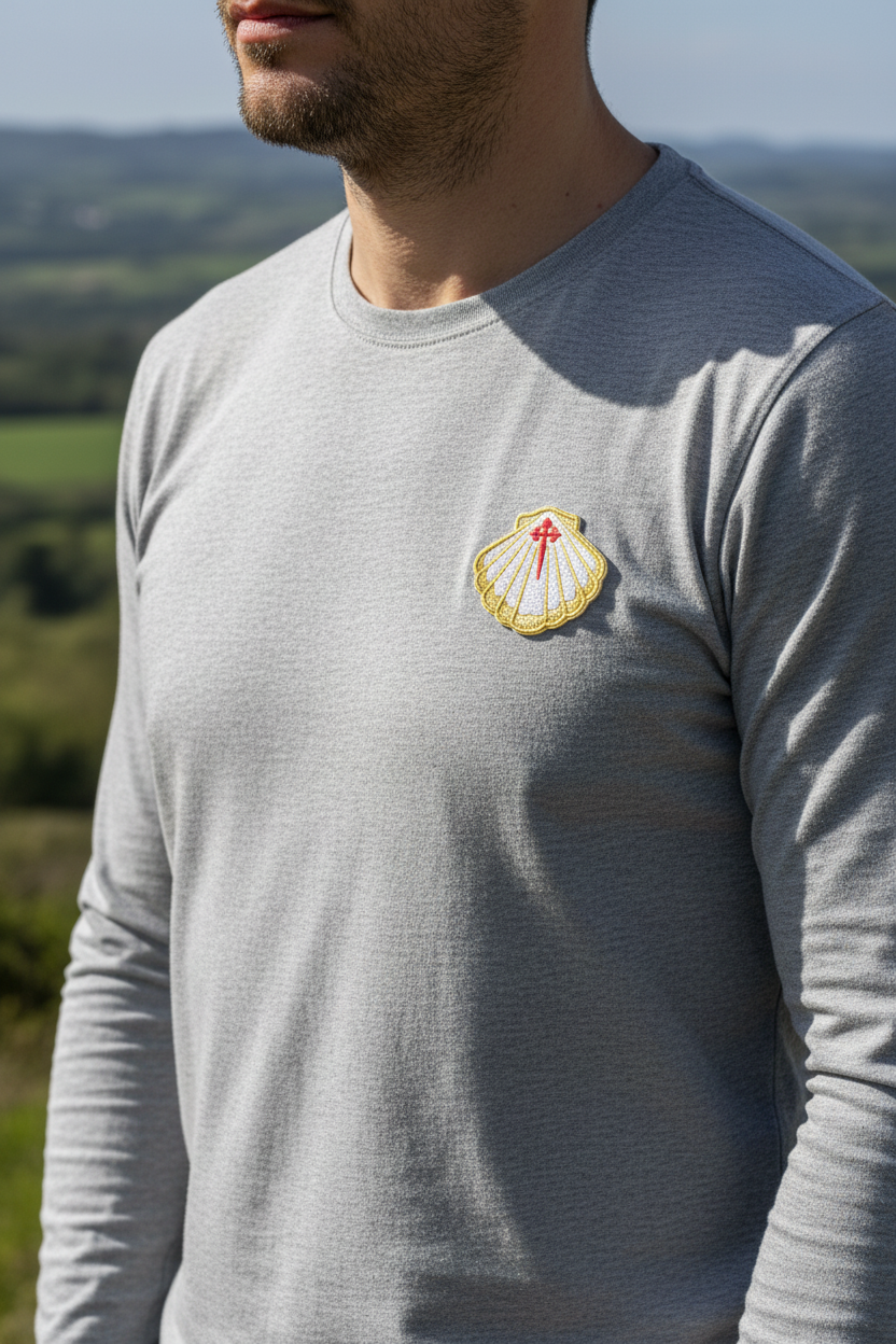 Pilgrim Artifact sparkling gold scallop shell iron-on patch on the chest of a grey long sleeve shirt